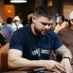 A poker player concentrating during a game in a lively casino atmosphere.